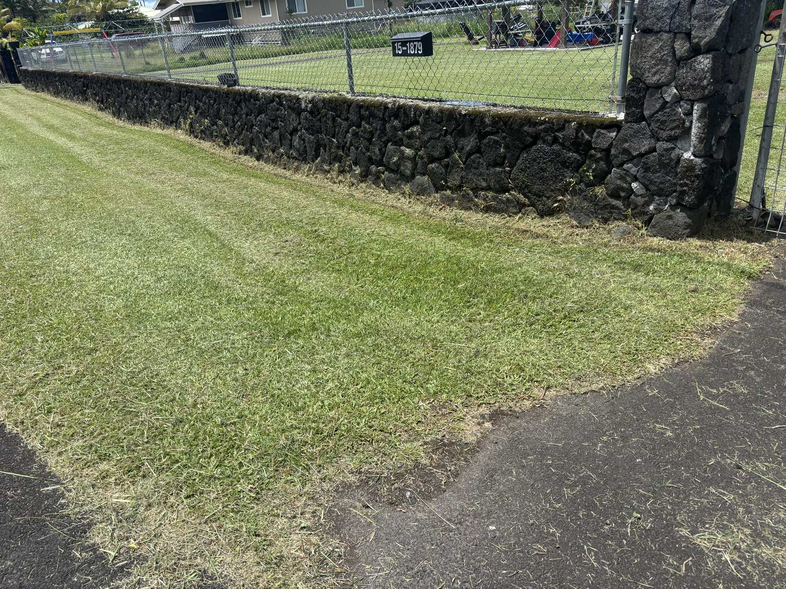 Same wall corner with freshly striped lawn after mowing