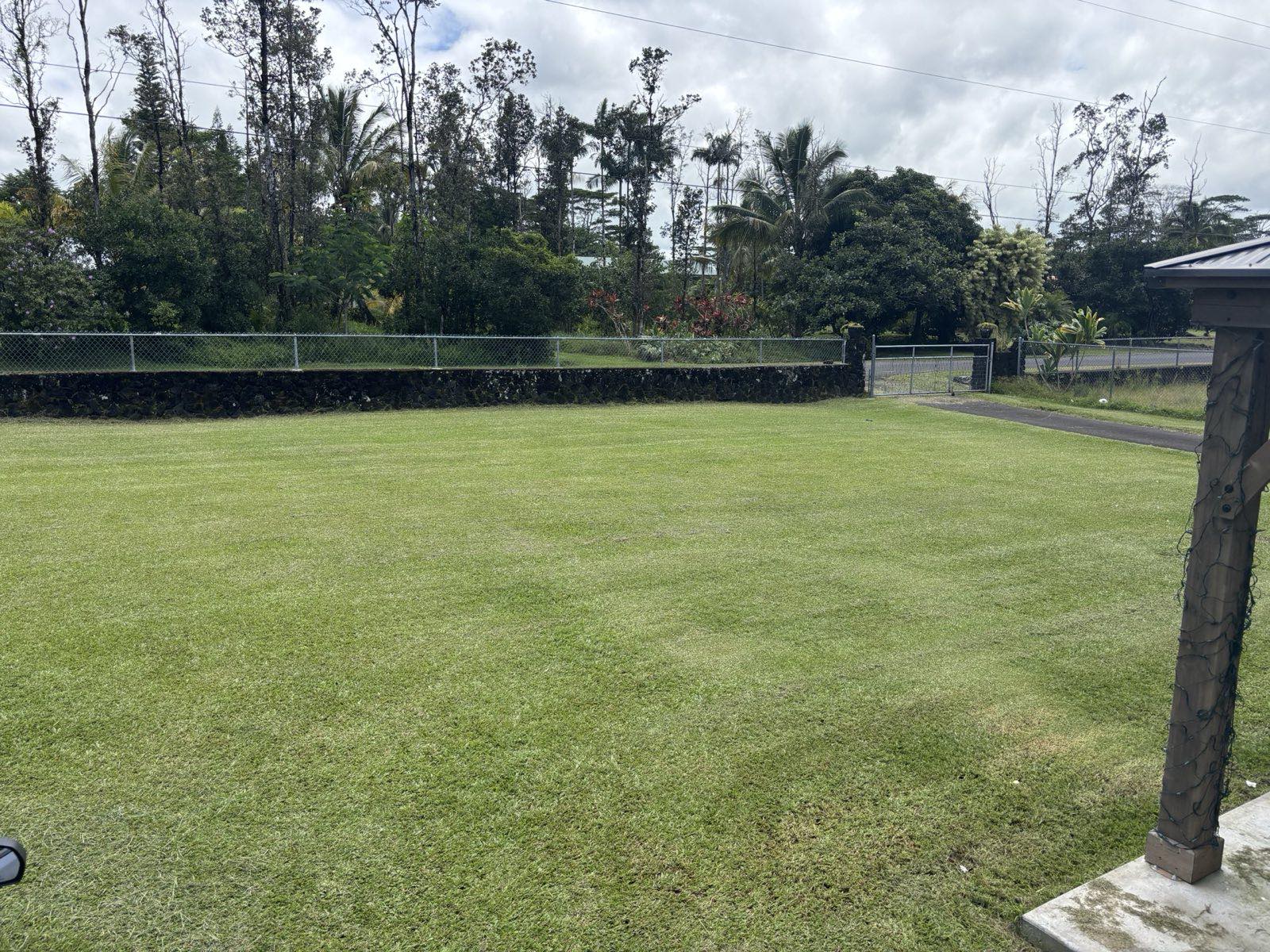 Freshly maintained wide open lawn bordered by a lava rock wall in Hawaiian Paradise Park